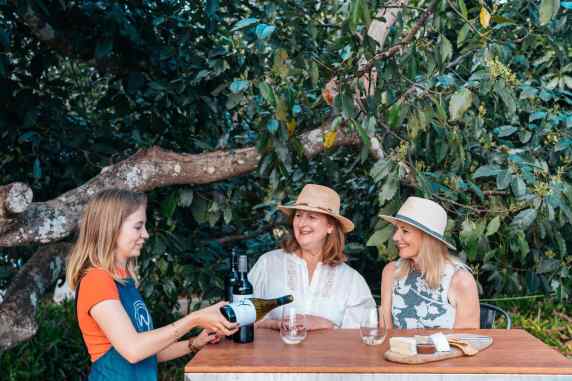 A staff member pouring wine for two women at Tamborine Mountain