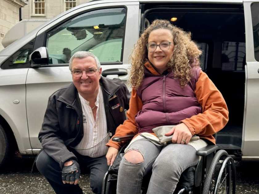 Carrie-Ann Lightley with her driver in front of a wheelchair accessible vehicle