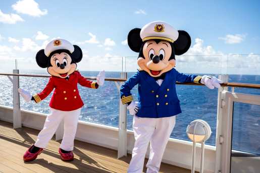 Mickey and Minnie Mouse dressed in sailing outfits on a cruise deck