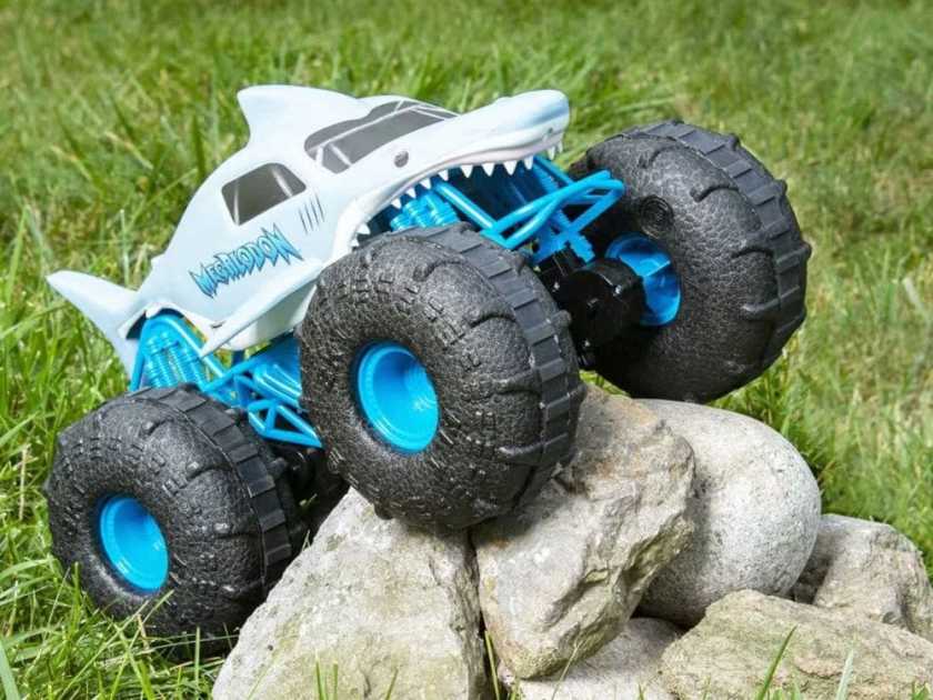 Remote control car with monster truck-style wheels going over rocks